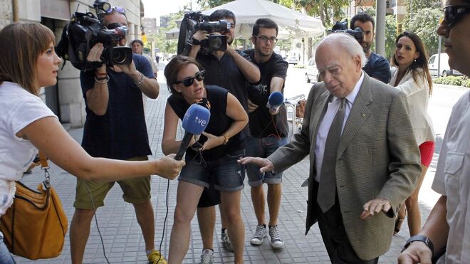 Varios periodistas esperan a Jordi Pujol en la puerta de su domicilio tras sus vacaciones.