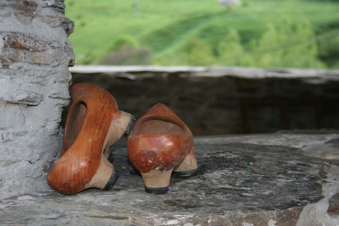 Un par de madreñas, el calzado típico asturiano, con el valle de Naviego de fondo