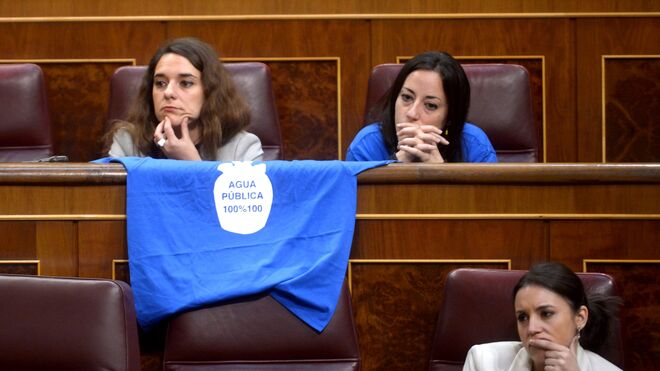 Diputadas de Podemos cuelgan del escaño, a modo de tendedero, una camiseta reivindicativa sobre el agua pública.