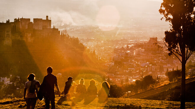 Un grupo de amigos contempla la puesta de sol en el Sacromonte de Granada.