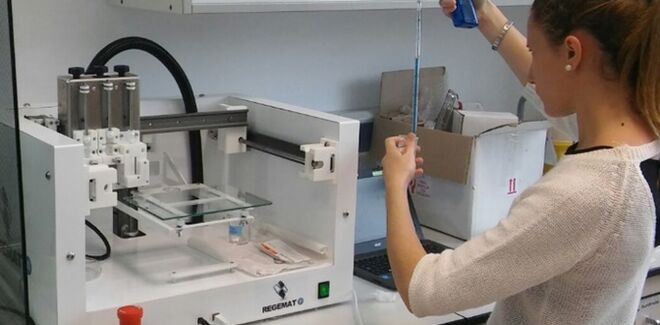Una técnico rellena de material la bioimpresora