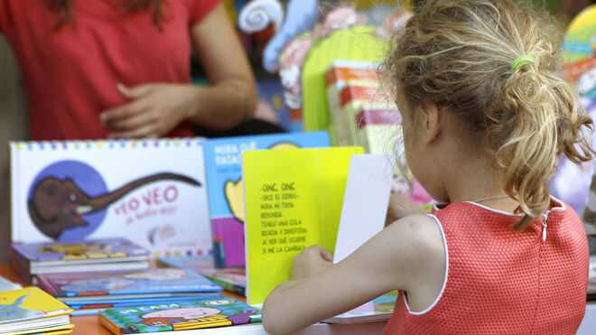 Una niña hojeando libros en una feria
