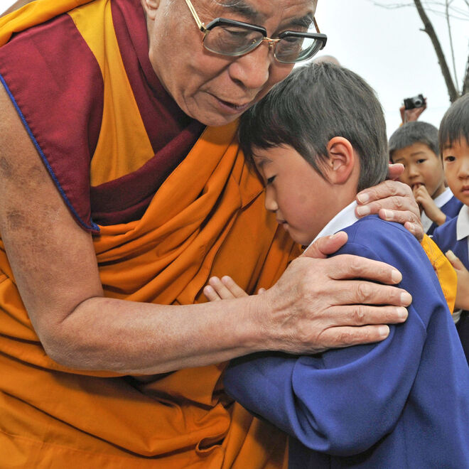 El líder espiritual tibetano, el Dalai Lama, abraza a un menor que perdió a sus padres en el terremoto y tsunami en la localidad japonesa de Ishinomaki