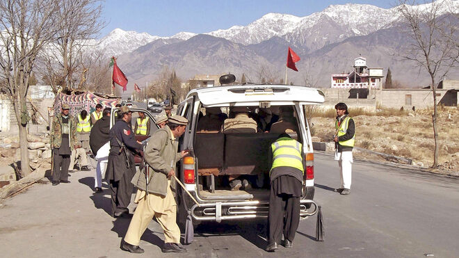 Unos oficiales de las fuerzas de seguridad paquistaníes inspeccionan un vehículo en la localidad paquistaní de Parachinar, situada en unos 200 kilómetros al suroeste de la ciudad de Peshawar y próxima a las montañas de Tora.