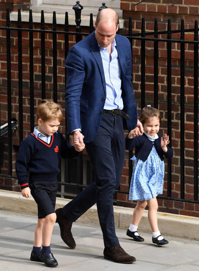 El príncipe William, de la mano de sus hijos, yendo a ver al recién nacido al hospital.