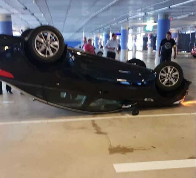 Coche volcado de Uber en l aeropuerto del Prat