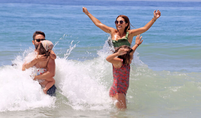 Paula, con su hija, y unos amigos, saltando las olas.