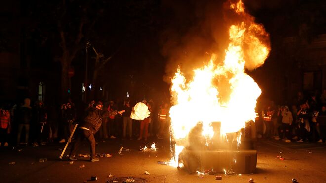 Los manifestantes incendian un contenedor durante los altercados tras la concentración convocada por los CDR bajo el lema "Olimpiada Republicana", este jueves en los Jardinets de Gràcia de Barcelona.