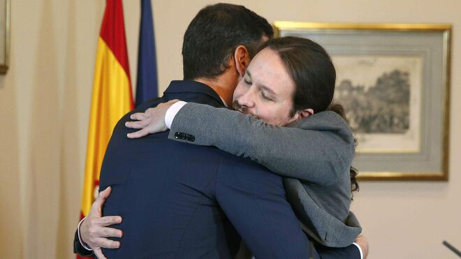 Sánchez e Iglesias se abrazan tras la firma del pacto.