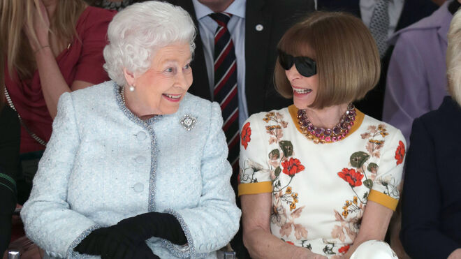 Wintour junto a la Reina Isabel II de Inglaterra durante un desfile de moda