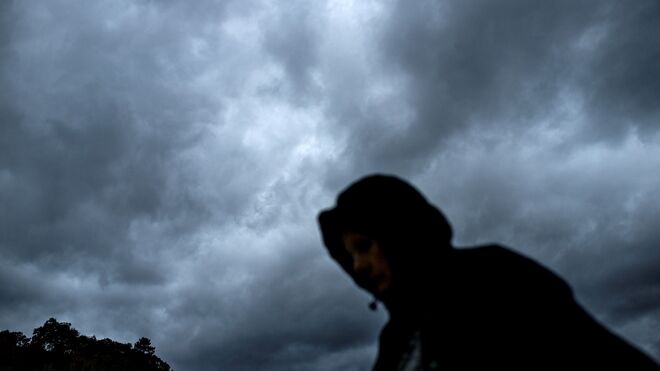 Una mujer camina bajo un cielo nublado en Ourense.