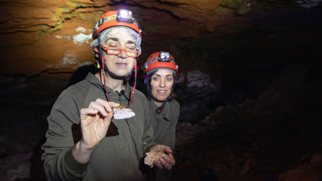 Ana Alonso y Rebeca Martín muestran algunas de las formaciones de aragonito de la cueva