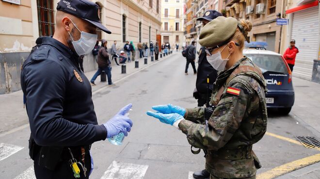 Un policía local de Murcia ofrece gel desinfectante a una militar del Ejército de Tierra.