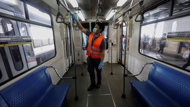 Un trabajador desinfectando un tren en Filipinas