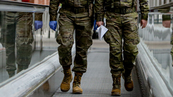 Dos militares caminan por una cinta desplazadora