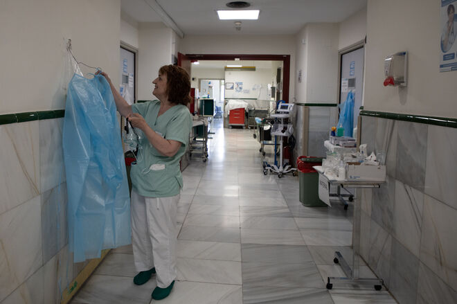 Una sanitaria coloca una bata en uno de los pasillos del Hospital Gregorio Marañón
