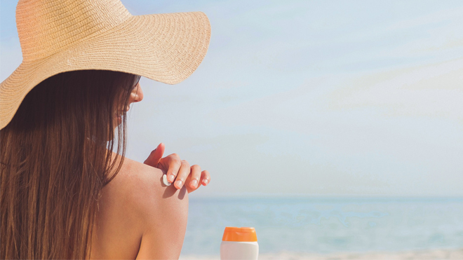 Mujer utilizando crema protectora para tomar el sol