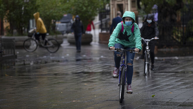 Varias personas montan en bici bajo la lluvia
