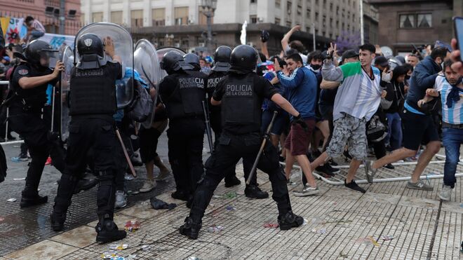 Un grupo de personas choca con la policía durante la espera para poder ingresar al velatorio de Diego Armando Maradona.EFE