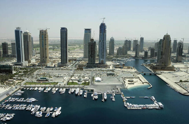 A la izquierda, vista parcial del Dubai Creek Golf, con el club náutico al fondo. A la derecha, detalle del Hotel Emirates Towers.