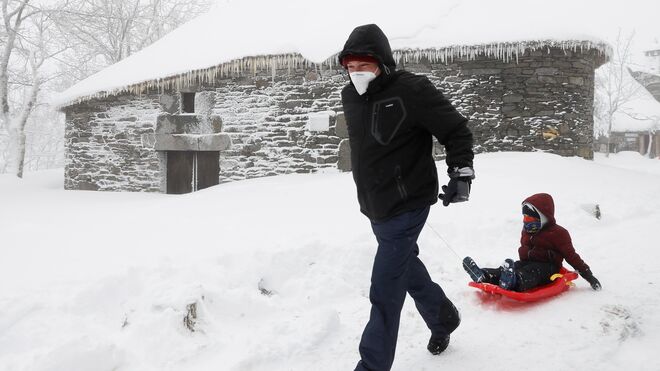Un hombre y su hijo disfrutan de la nieve en O Cebreiro (Lugo).
