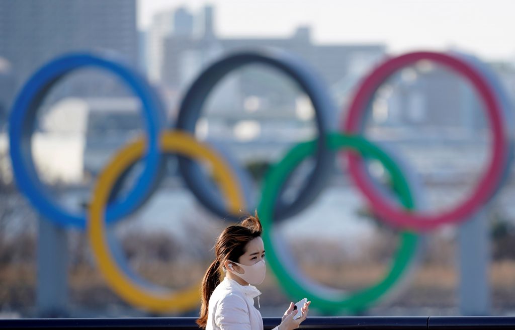 Una joven paseando junto a los anillos de los Juegos Olímpicos de Tokio.