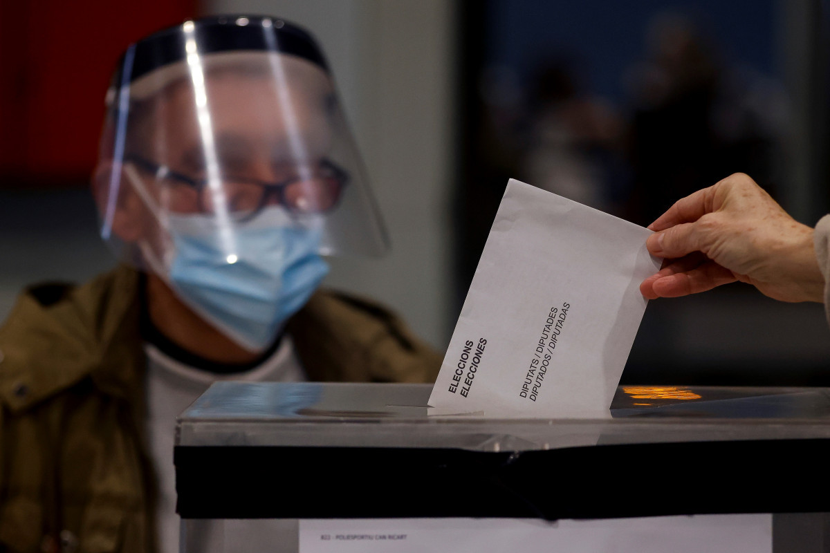Una persona deposita su voto en el polideportivo Can Ricart del barrio del Raval de Barcelona hoy, domingo, cuando Cataluña celebra unas nuevas elecciones al Parlament.
