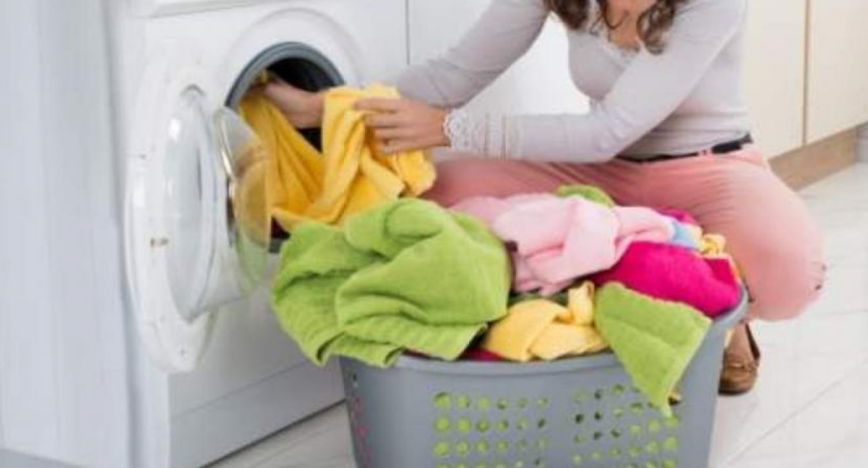 Una mujer saca la ropa de la lavadora