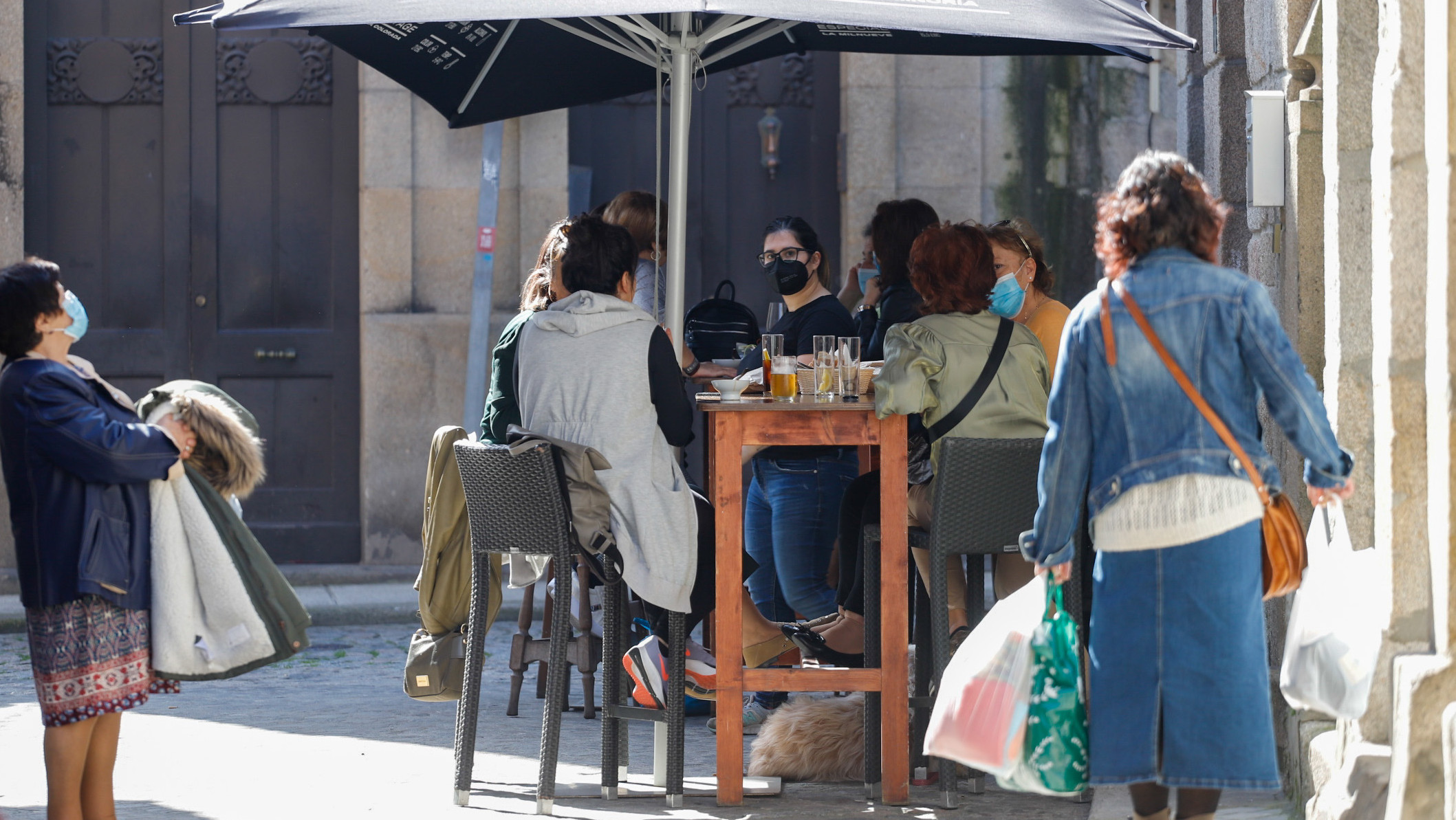 Varias personas en la terraza de un bar en el barrio de Bouzas, en Vigo, Galicia (España).