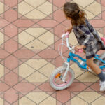 Una niña jugando con su bicicleta en la Plaza de España