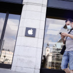 Una persona protegida con mascarilla pasa junto a la tienda Apple en la Puerta del Sol.