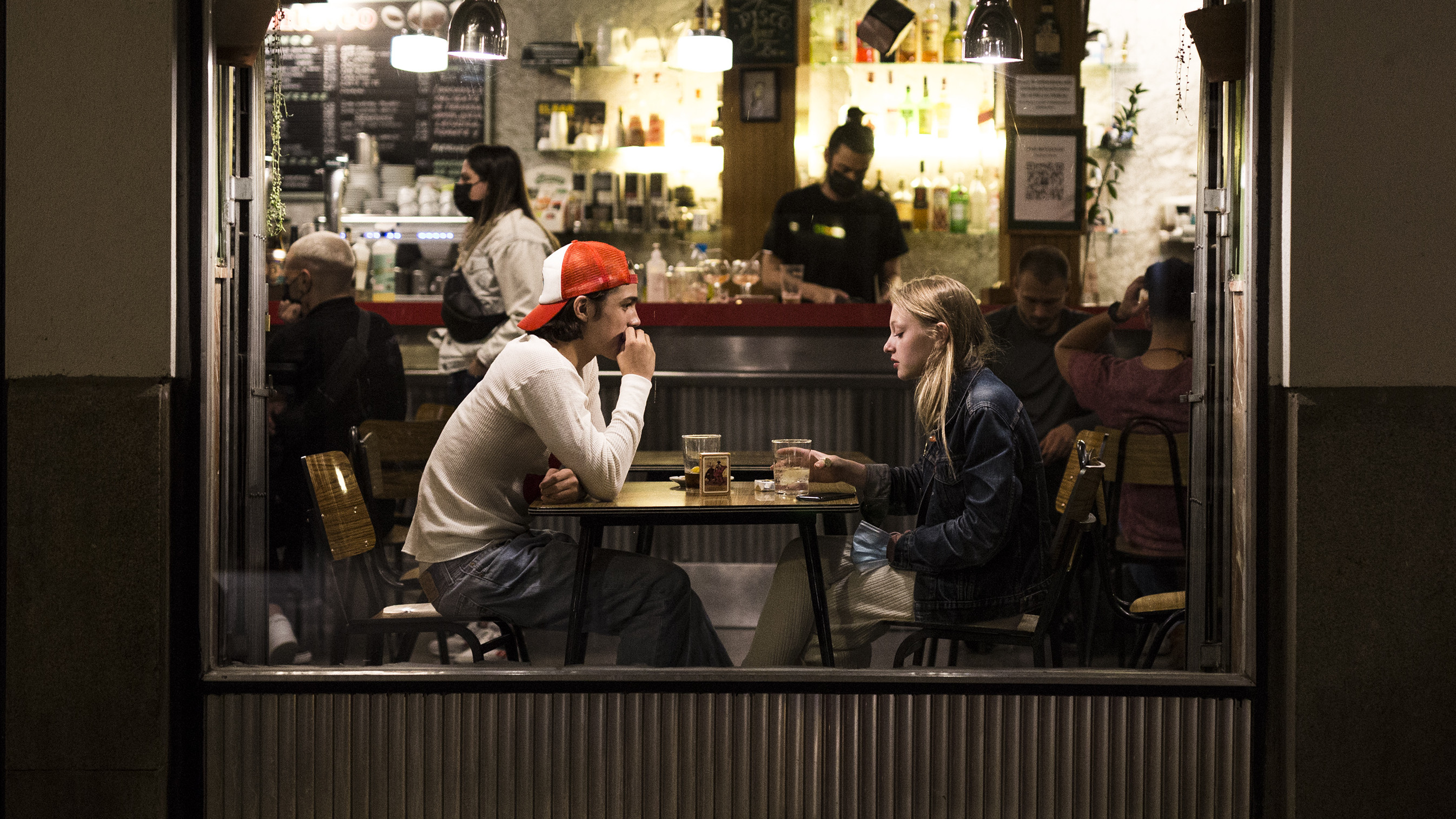 Dos jóvenes en el interior de un bar en el barrio de las Letras de Madrid.