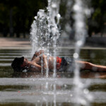 Una persona se refresca en una de las fuentes del centro de Córdoba, este sábado.