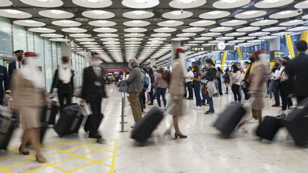 Un hombre espera mientras otros pasajeros llegan a la Terminal T4 del Aeropuerto Adolfo Suárez Madrid - Barajas.