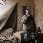 Una mujer observa su casa, destrozada por los bombardeos en Ucrania.