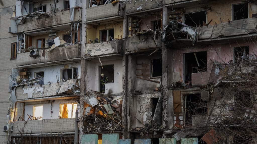 Bomberos inspeccionan un edificio bombardeado en la ciudad de Kiev (Ucrania).