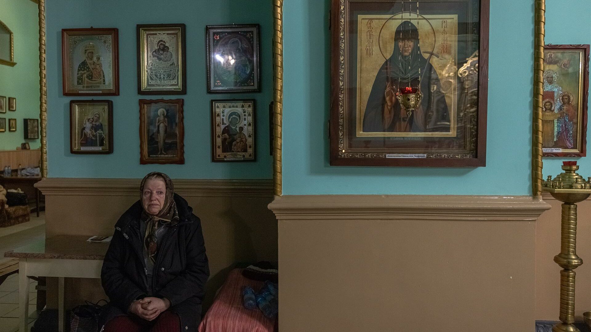 Una mujer en una iglesia después de que su casa haya sido destruida en Járkov (Ucrania)