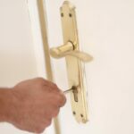 Un hombre introduce una llave en la cerradura de la puerta de una vivienda