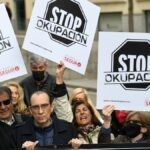 Varias personas, con pancartas que rezan 'Stop Okupación' en la concentración en apoyo a los afectados por la okupación, a 27 de marzo de 2022, en Madrid (España).