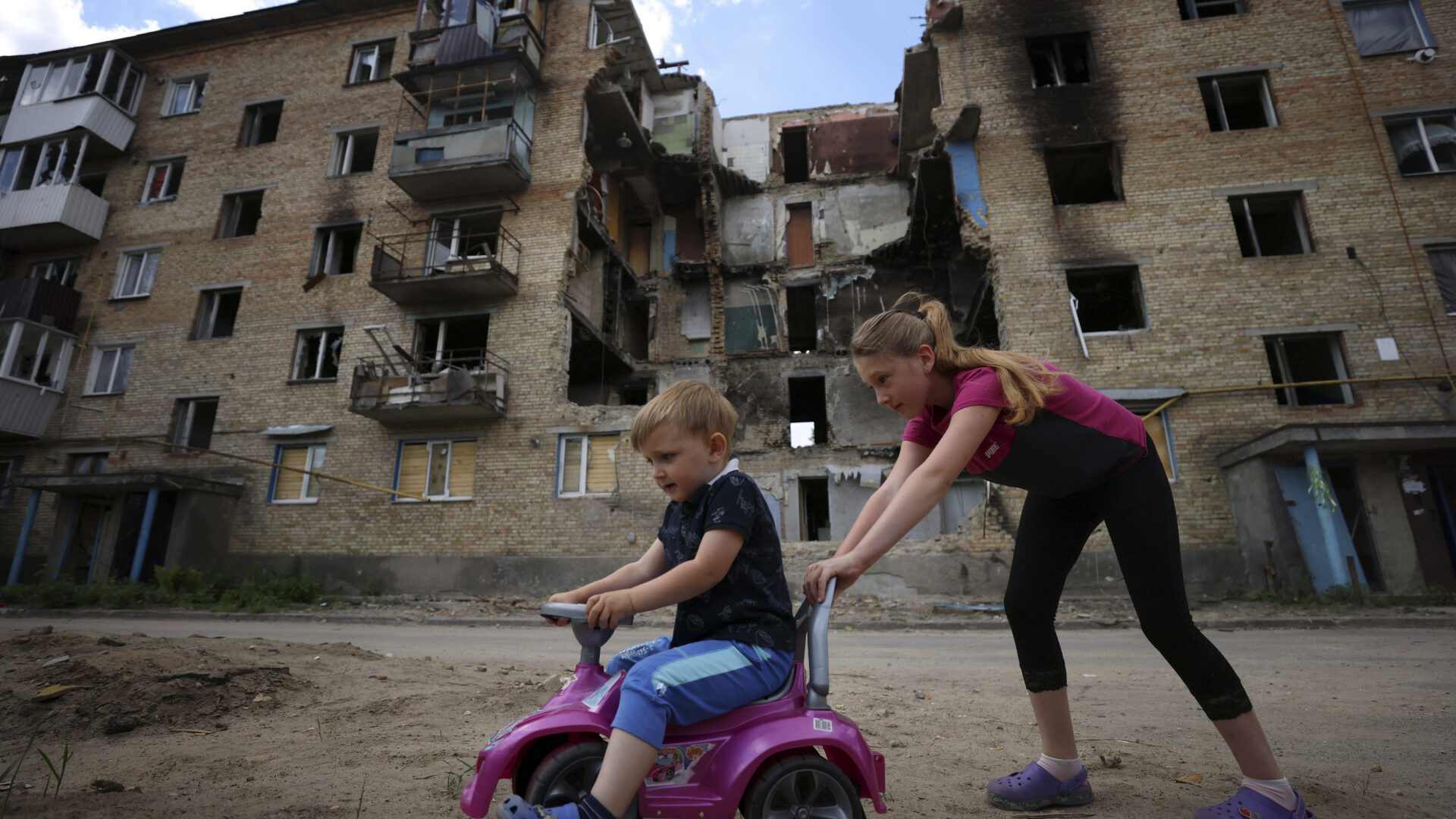 Dos niños juegan frente a un bloque de apartamentos bombardeado en Horenka, cerca de Kiev (Ucrania).