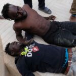 Migrantes descansando después de saltar la valla de Melilla