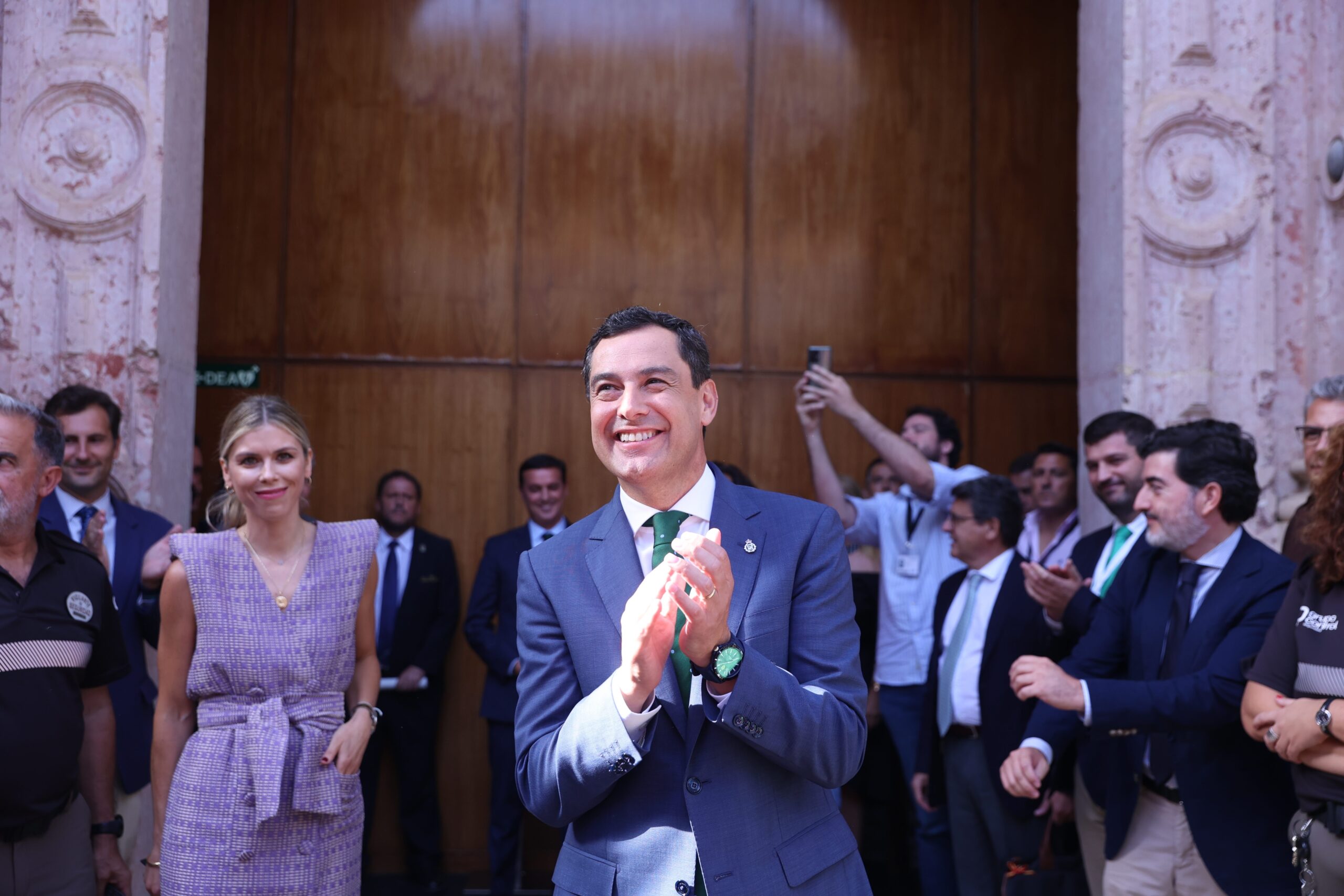 El recién investido presidente de la Junta de Andalucía, Juanma Moreno, a las puertas del Parlamento con su mujer, Manuel Villena, en segundo plano este jueves. FOTO/ Europa Press