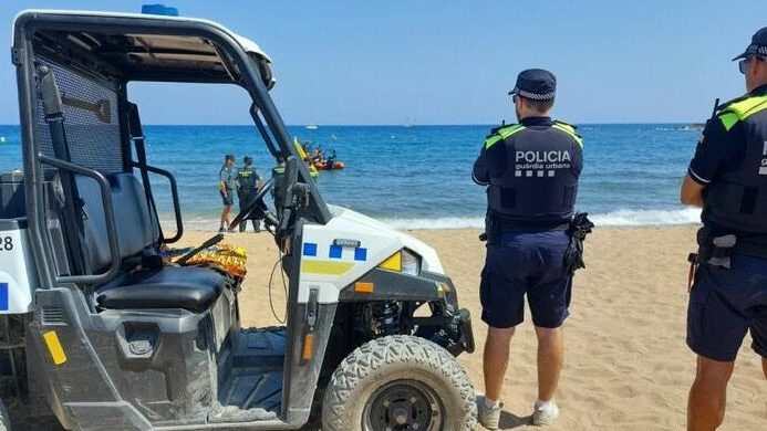 Agentes de la Guardia Urbana y de la Guardia Civil controlan la playa desalojada por un posible artefacto explosivo