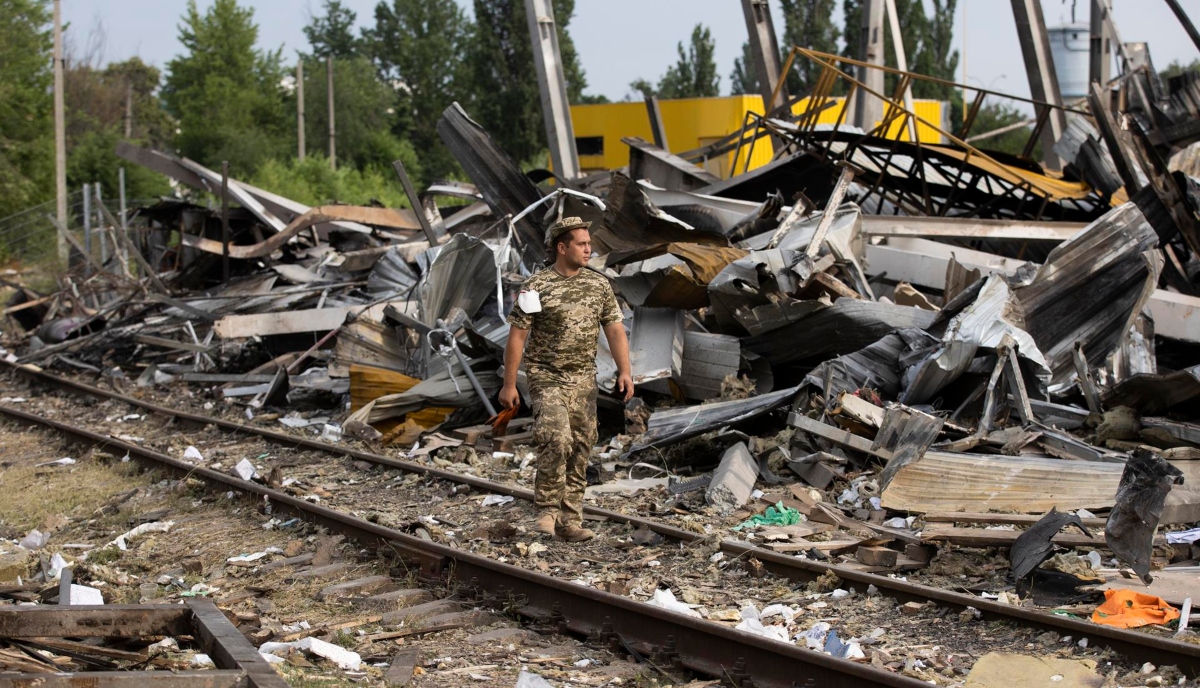 Un militar ucraniano anda sobre los escombros de una explosión