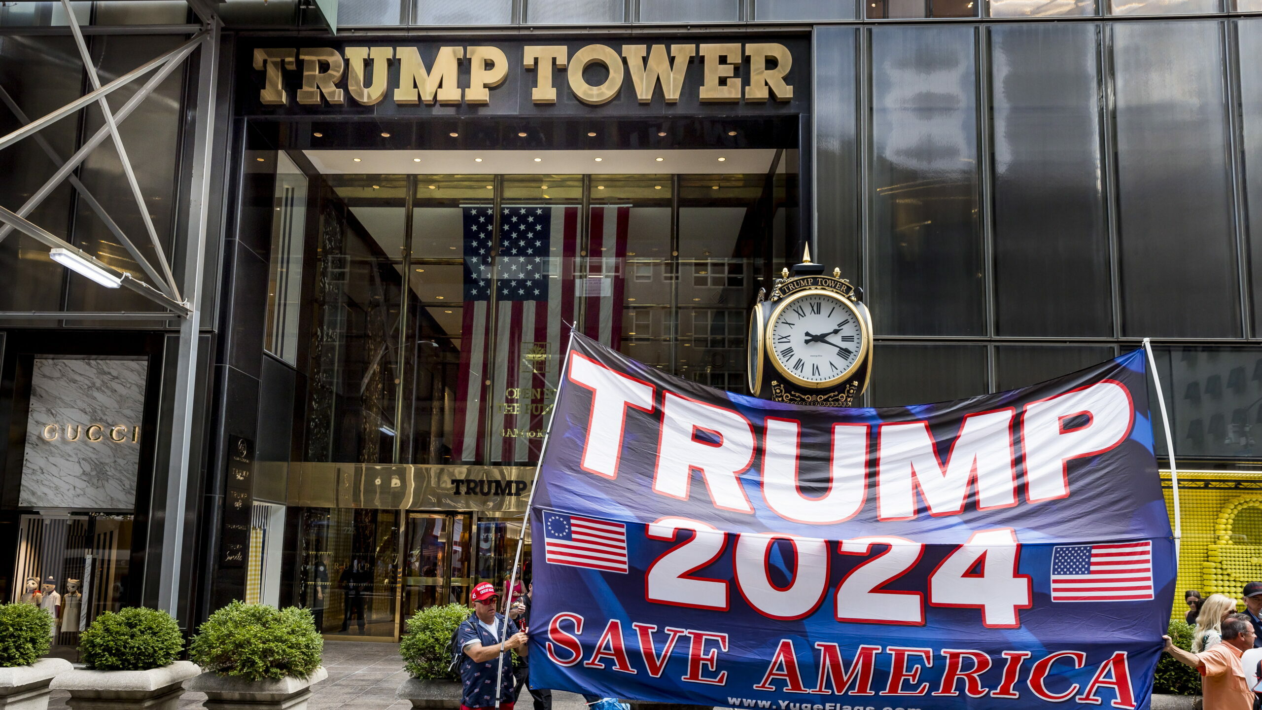 Partidarios del expresidente de los Estados Unidos, Donald Trump, sostienen una pancarta frente a la Torre Trump en Nueva York/ EFE