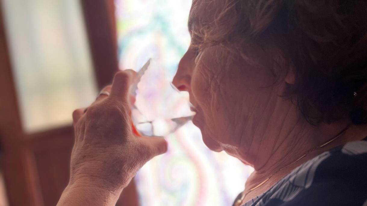 Una anciana bebiendo agua