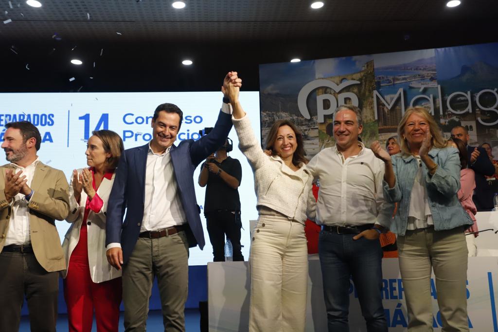 El presidente de la Junta de Andalucía, Juanma Moreno, alza el brazo de la nueva presidenta del PP de Málaga, Patricia Navarro, este sábado en Marbella. Foto/ PP