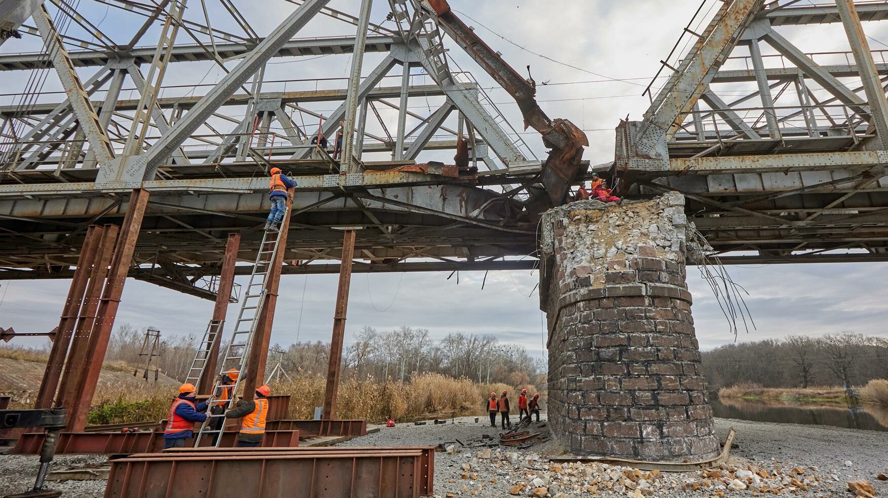Workers repair a railway bridge after it was damaged in fighting between the Ukrainian and Russian armies in the town of Kupiansk