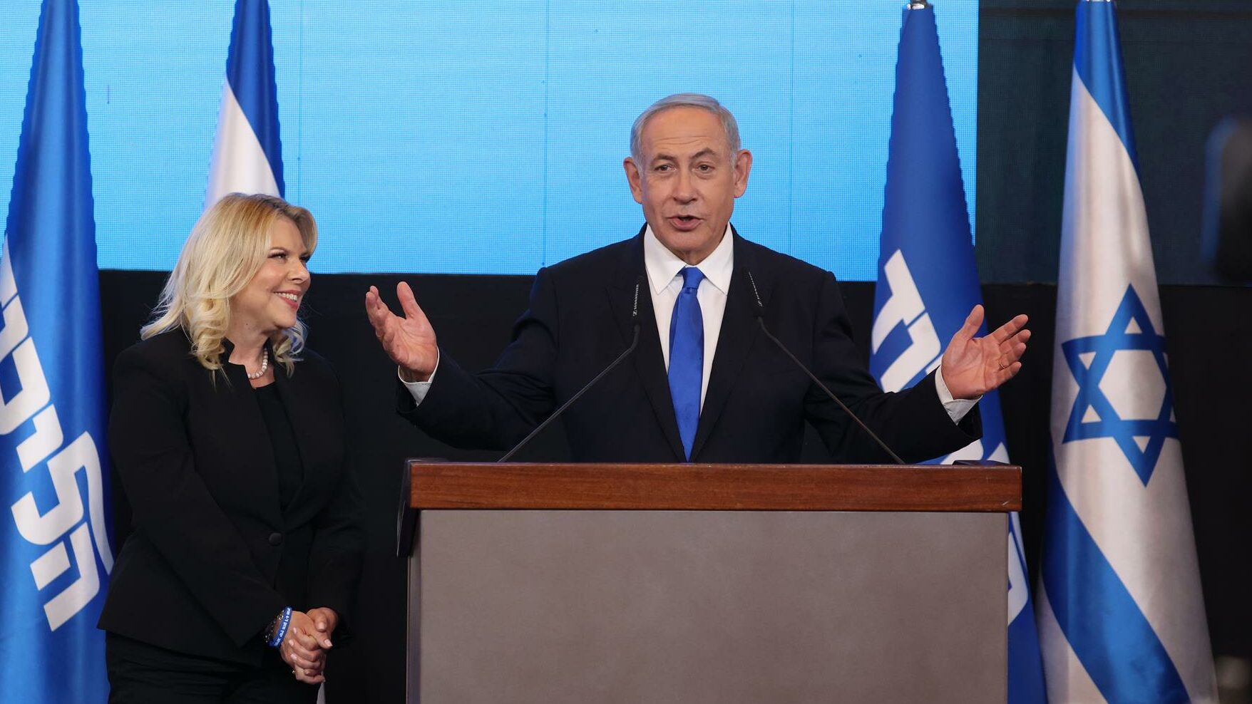 El ex primer ministro israelí y líder del partido Likud, Benjamin Netanyahu (der.), habla mientras su esposa Sara (izq.) observa el evento electoral final del partido Likud en Jerusalén.