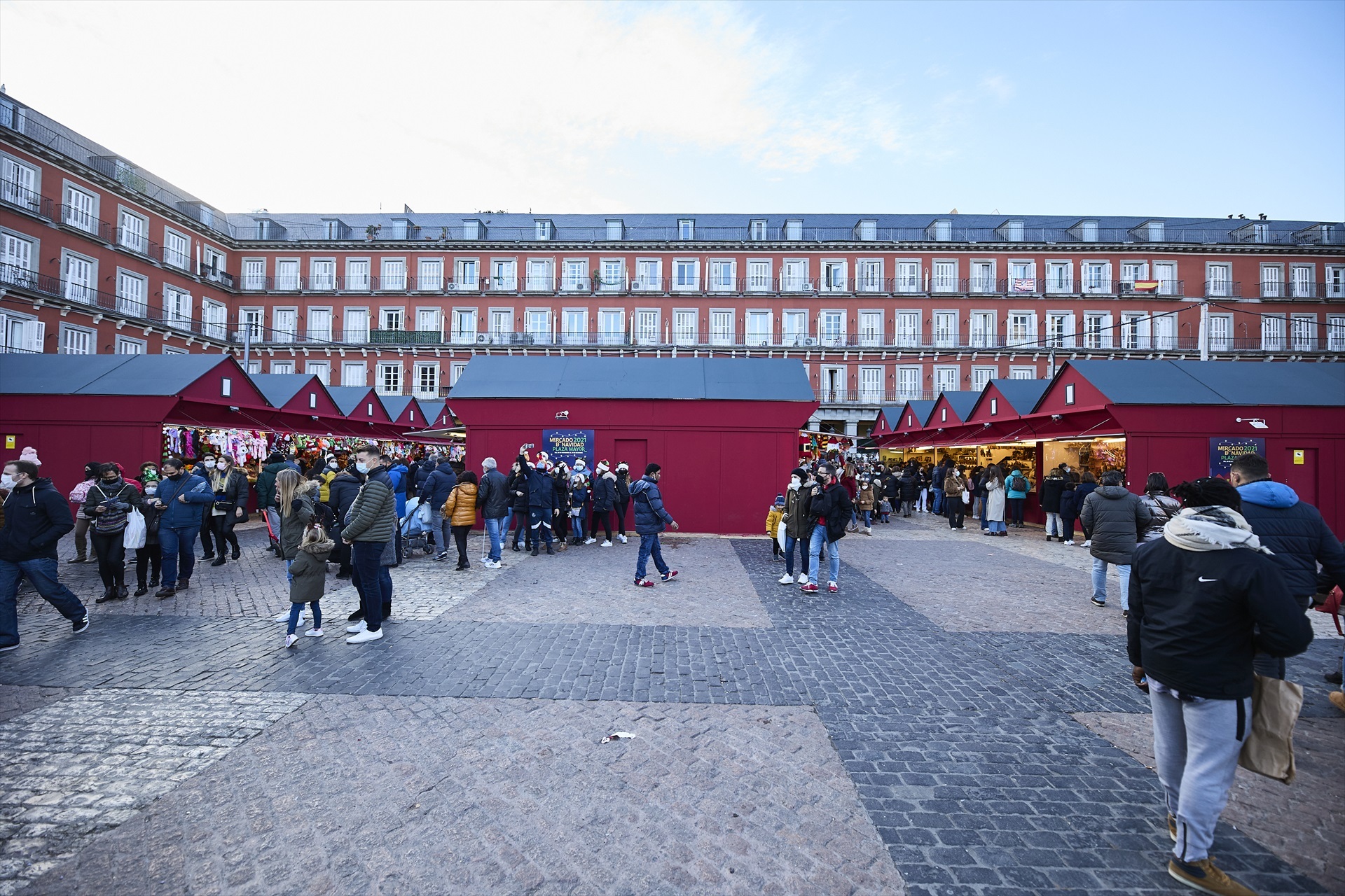 Un grupo de personas asiste al mercadillo navideño instalado en la madrileña plaza mayo.